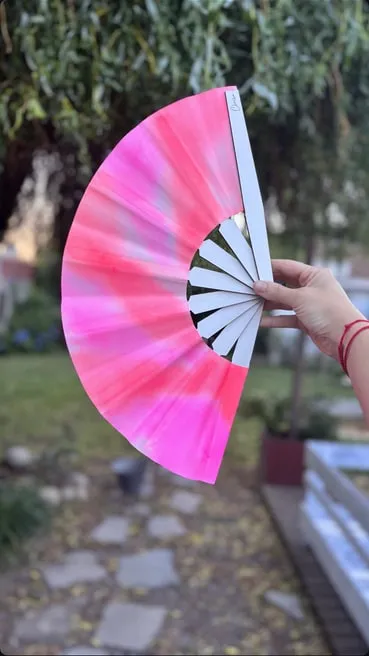 Abanico grande abierto rosa fucsia en degradé, en un jardín