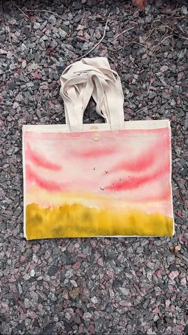 Tote bag de gabardina cruda con un atardecer en acuarela rosa y amarillo
